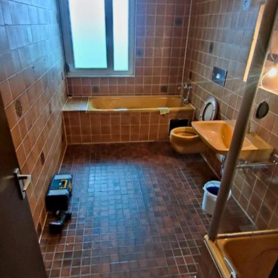 Vorher: altes Bad mit braunen Fliesen und Badewanne
